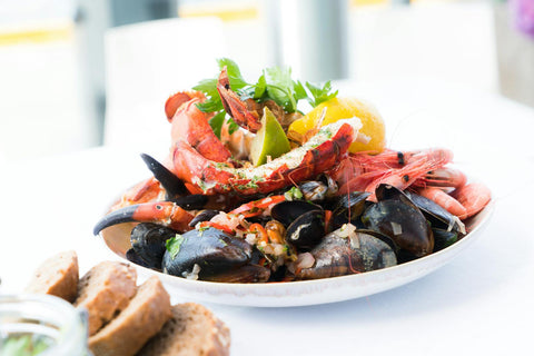 Mejillones frescos abiertos en plato de cerámica con limón
